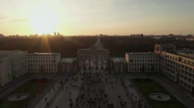 Berlin 'deki Brandenburg Kapısı' nda güzel gün batımı ışığında bir sürü insan ve turist var. 