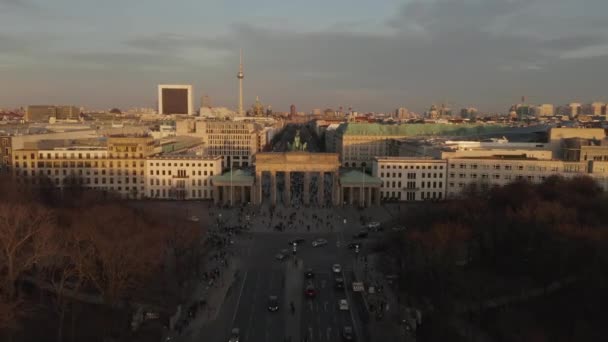 AERIAL: Puerta de Brandeburgo en Berlín con vista a la Torre Alexander Platz TV con hermosa luz del atardecer — Vídeo de stock