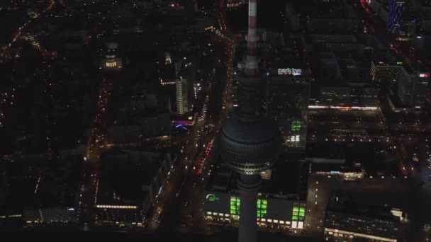 AERIAL: Över Berlin Tyskland TV Tower Alexanderplatz på natten med City Lights trafik — Stockvideo