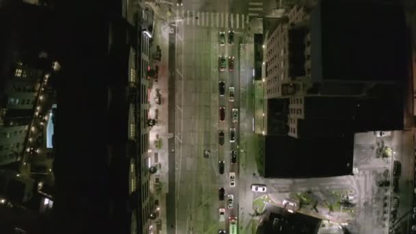 AERIAL: Vista aérea de la calle cinematográfica por la noche en Los Ángeles con semáforos — Vídeo de stock