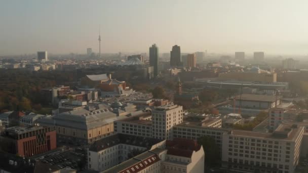 AERIAL: Vista de Berlín, Alemania Rascacielos Skyline con sunflair entre rascacielos en Hermosa Naranja Otoño Sunlight Haze — Vídeos de Stock