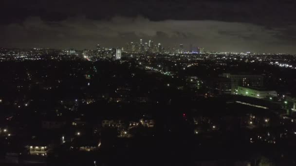 AERIAL: Over Dark Hollywood Los Angeles en la noche con nubes sobre el centro y luces de la ciudad — Vídeo de stock