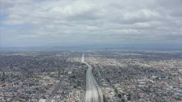 AERIAL: Nádherný výhled na nekonečné město Los Angeles, Kalifornie s velkou dálnicí spojující se s centrem na oblačný den — Stock video