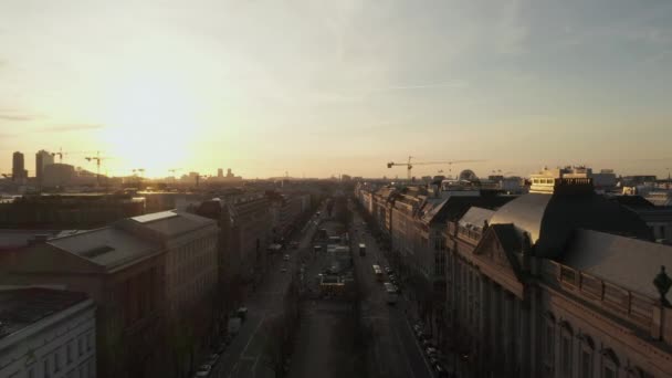 AERIAL: Spektakulärer Tiefflug durch belebte Berliner Straße in Richtung Brandenburger Tor im wunderschönen goldenen Sonnenuntergang — Stockvideo
