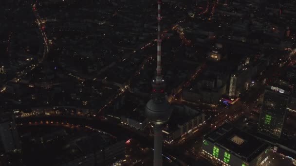 AERIAL: Över Berlin Tyskland TV Tower Alexanderplatz på natten med City Lights trafik — Stockvideo