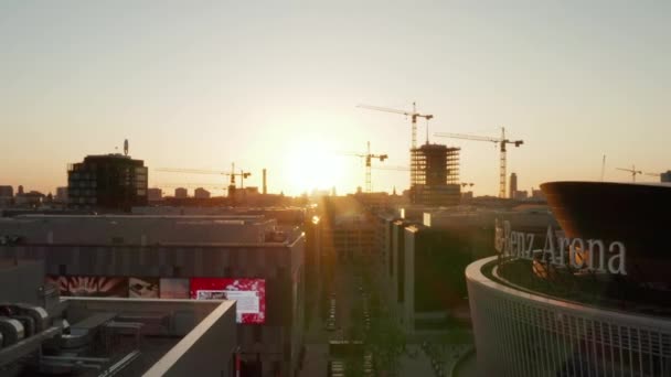 AERIAL: Hacia mercedes benz arena en Berlín, Alemania en la hermosa puesta del sol con Alexanderplatz TV Tower, Sunflairs — Vídeo de stock