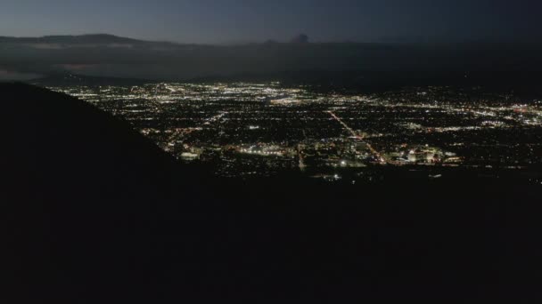 AERIAL: Éjszakai repülés Hollywood Hills felett, kilátással a völgyre, Burbankre és a városi fényekre — Stock videók