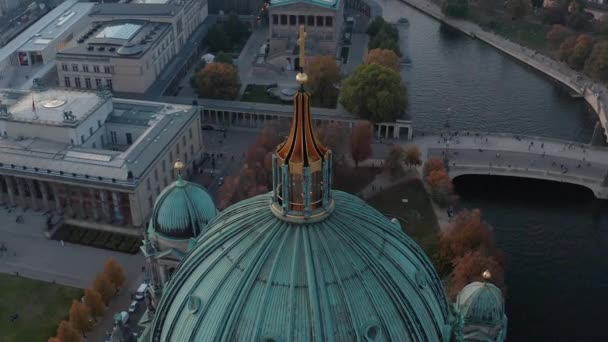 AERIAL: Círculo Catedral de Berlín Arriba con cruz de oro y calles en el fondo, Alemania en colores de otoño en la hermosa puesta del sol — Vídeo de stock