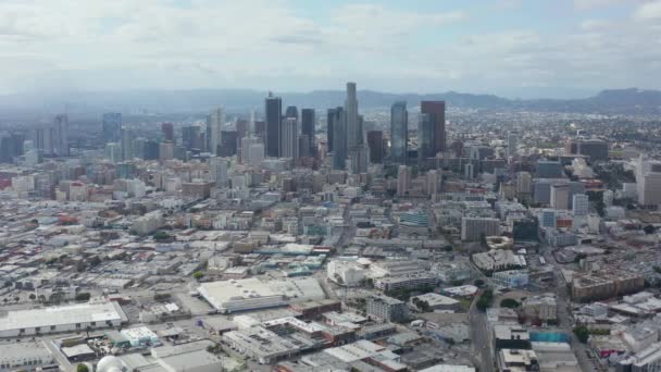 AERIAL: Långsamt cirkulerande centrum Los Angeles Skyline med Magasinkonst Distrct i förgrunden med blå himmel och moln — Stockvideo