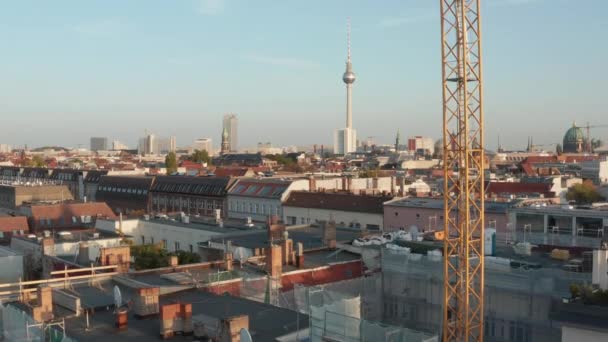 AERIAL: Flyg under Crane vid byggarbetsplats och korsning med biltrafik i Höstväder, Berlin, Tyskland — Stockvideo