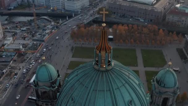 AERIAL: Circling Berlin Cathedral Top se zlatým křížem a ulicemi v pozadí, Německo v podzimních barvách při krásném západu slunce — Stock video