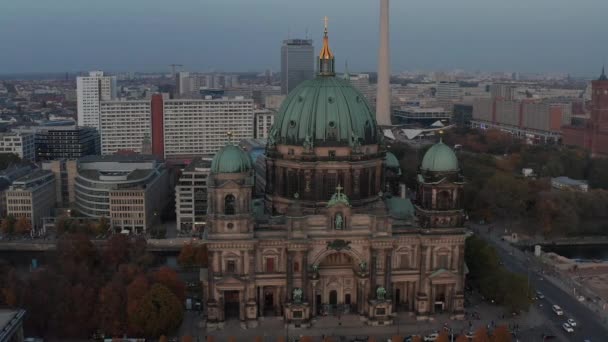 AERIAL: Alrededor de la Catedral de Berlín hermosa estructura antigua en vibrantes colores de otoño con cruz dorada en la parte superior y la vida de la ciudad que se mueve alrededor — Vídeo de stock
