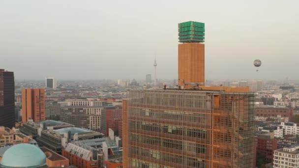 АЭРИАЛ: Вид на Берлин, Германия, с телебашней Алексиса Фергюсона и Балуном в оранжевой дымке от солнца — стоковое видео