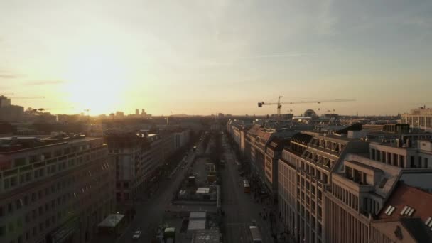 AERIAL: Scenic low flight trough busy Berlin, Germany Street towards Brandenburg Gate in beautiful golden sunset light — Stock Video