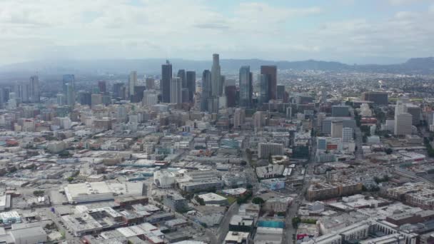 AERIAL: Långsamt cirkulerande centrum Los Angeles Skyline med Magasinkonst Distrct i förgrunden med blå himmel och moln — Stockvideo