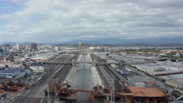 AERIAL: Kilátás a Los Angeles folyó híd alatt épül építési telek felhős ég — Stock videók