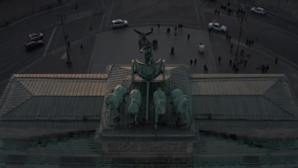 АЭРИАЛ: Закрытый вид птиц на зеленую статую Фарига на площади Гейт в Берлине, Германия, с красивым закатом солнца — стоковое видео