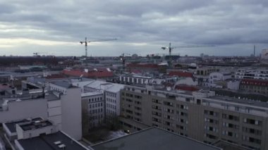 Günbatımında inşaat vinçleriyle Berlin Almanya 'nın merkezinde yavaşça uçuyor. 