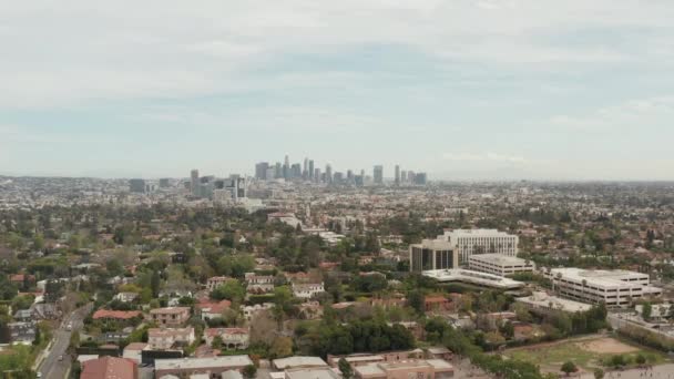 AERIAL: Utsikt över Los Angeles, Kalifornien med centrum i bakgrunden och vackra rika gröna träd och bostadshus på mulen dag — Stockvideo