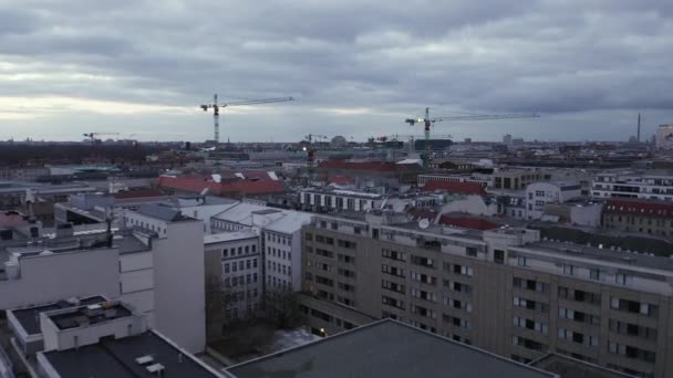 AERIAL: Pomalu letí nad centrem Berlína Německo s jeřáby staveniště při západu slunce — Stock video