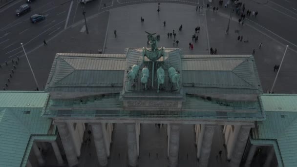 AERIAL: Epikus közelkép Brandenburg kapu gyönyörű naplemente fény felfedi autó forgalom a háttérben — Stock videók