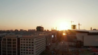 Berlin, Almanya 'daki Mercedes Benz arenasına doğru Alexanderplatz TV Kulesi ve Sunflairs ile güzel bir Sunset' te.