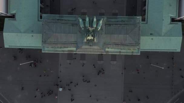 AERIAL: slow Birdsview Overhead shot of Brandenburg Gate roof with Quadriga statue close up and people on the ground — 图库视频影像
