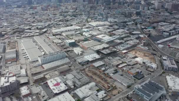 AERIAL: Skladiště District v Los Angeles zpomalit naklonit odhalit Downtown LA Skyline — Stock video