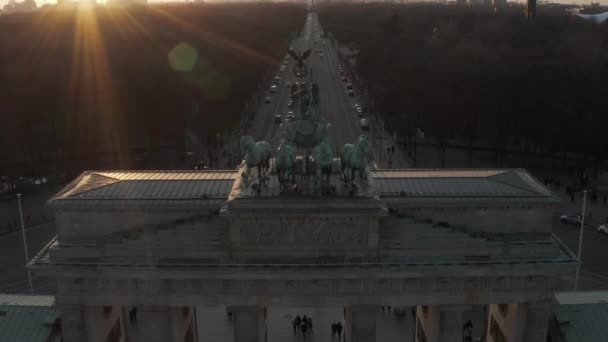 AERIAL: Langzaam naderende Brandenburger Tor in prachtig zonsondergang zonlicht en kantelen op Quadriga Green Statue in Berlijn, Duitsland — Stockvideo