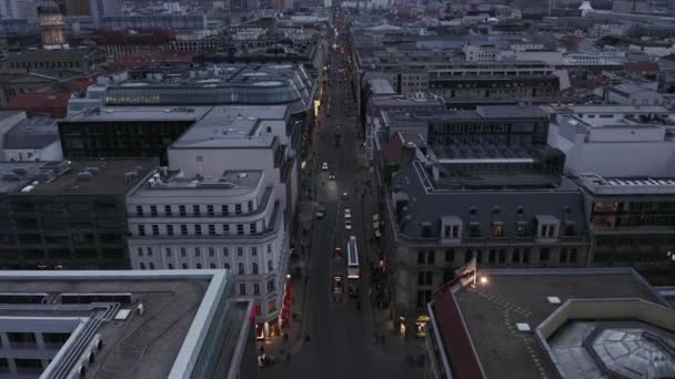 AERIAL: Χαμηλή Θέα στο Βερολίνο Mitte Friedrichstrasse και τα φώτα της πόλης της κυκλοφορίας αυτοκινήτων, σταθμούς του μετρό την ημέρα συννεφιά πριν από τη δύση του ηλίου — Αρχείο Βίντεο