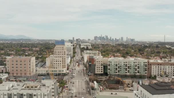 AERIAL: Vlucht over Wilshire Boulevard naar het centrum van Los Angeles, Californië met Constructions Site op de voorgrond op bewolkte dag — Stockvideo