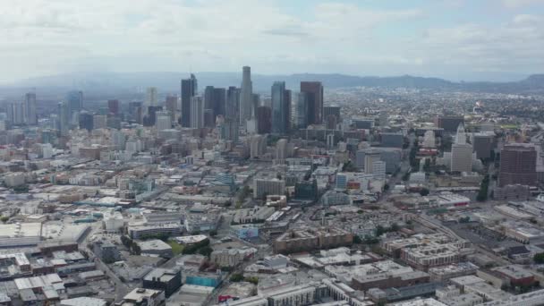 AERIAL: Langsam die Skyline der Innenstadt von Los Angeles umkreisen, mit Lagerhallen-Kunst im Vordergrund, blauem Himmel und Wolken — Stockvideo