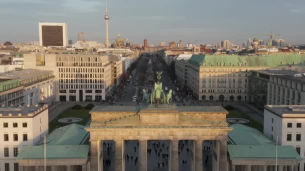 AERIAL: Långsamt närmar Brandenburger Tor och Tiergarten i vacker solnedgång solljus med nära utsikt över Quadriga Green Statue i Berlin, Tyskland — Stockvideo