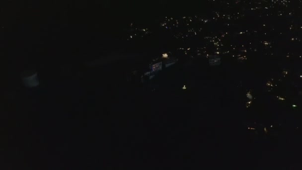 AERIAL: Slow Tilt Przesuń się po Hollywood Hills w nocy ujawniając Los Angeles City Lights — Wideo stockowe