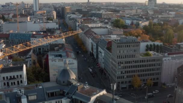 AERIAL: Flight over Crane at construction site and intersection with car traffic in Fall weather, Berlin, Germany — Stock Video