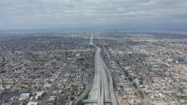 AERIAL: Spektakulärer Blick über die endlose Stadt Los Angeles, Kalifornien, mit großer Autobahnverbindung in die Innenstadt am bewölkten Tag — Stockvideo