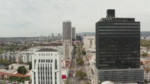 AERIAL: Vlucht over Wilshire Boulevard in de buurt van Street and Buildings with Car Traffic in Los Angeles, Californië op bewolkte dag — Stockvideo