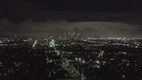 AERIAL: Over Dark Hollywood Los Angeles en la noche con nubes sobre el centro y luces de la ciudad — Vídeo de stock