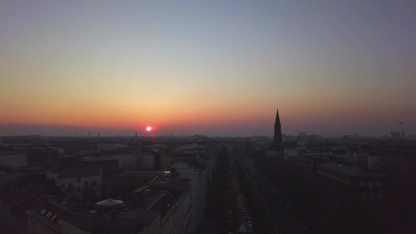 AERIAL: Sobre trilhas de trem da cidade de Berlim com o pôr do sol — Vídeo de Stock
