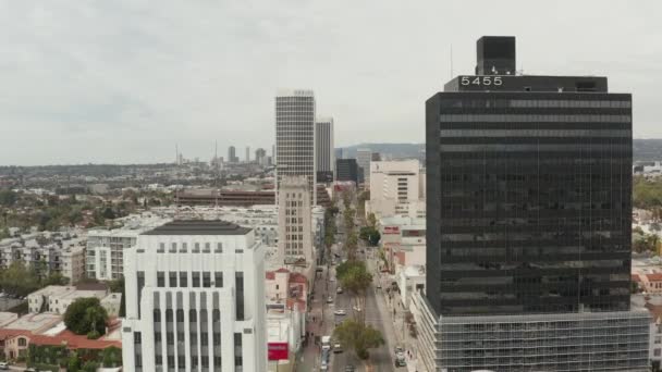 AERIAL: Vlucht over Wilshire Boulevard in de buurt van Street and Buildings with Car Traffic in Los Angeles, Californië op bewolkte dag — Stockvideo