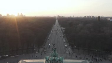 17 Haziran Caddesi ve Tiergarten 'in üzerinde Berlin Zafer Sütunu Brandenburg Kapısı' nı gün batımında güzel bir şekilde gözler önüne seriyor. 