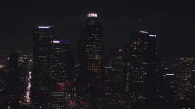 Şehir merkezindeki gökdelenlere, Skyline Los Angeles, California 'ya gece yarısı şehir ışıklarıyla uçuyorum., 