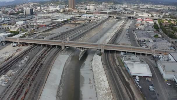 AERIAL: Řeka Los Angeles s vodou na oblačném nebi vedle kolejí vlaku — Stock video