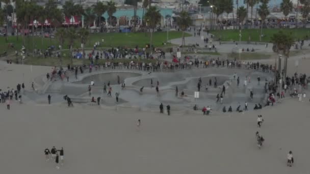 AERIAL: Towards Venice Beach Skatepark with Skaters from Ocean, Sunset, Los Angeles, California — стокове відео