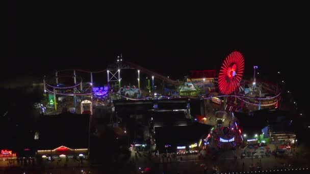 AERIAL: Vista deslumbrante no cais de Santa Mônica à noite com roda gigante e luzes coloridas , — Vídeo de Stock