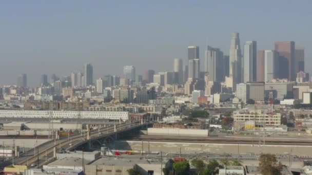 AERIAL: Río LA, vías de tren con el centro de Los Ángeles en el fondo, la luz del sol — Vídeos de Stock