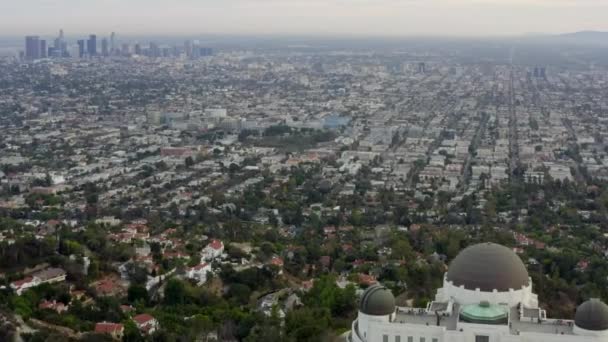 AERIAL: Sopra l'Osservatorio Griffith con Los Angeles, California Skyline sullo sfondo alla luce del giorno, Nuvoloso — Video Stock