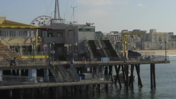 AERIAL: Voo reverso olhando para Santa Monica Pier em Los Angeles, Califórnia, Sunny, Blue Sky — Vídeo de Stock