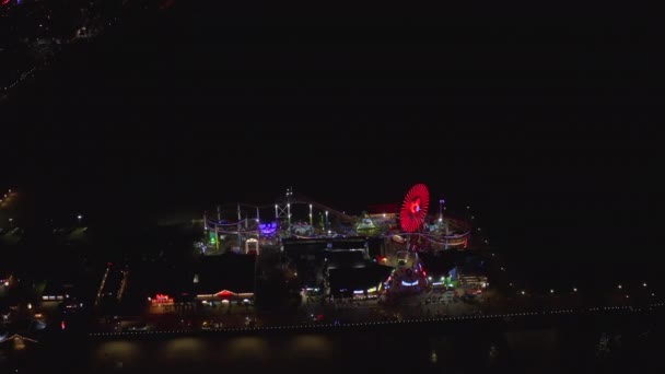 AERIAL: Πανέμορφη θέα στο Santa Monica Pier τη νύχτα με Ferris Wheel και πολύχρωμα φώτα, — Αρχείο Βίντεο