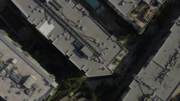 AERIAL: Birds Eye Vista sobre las calles del centro de Los Ángeles, California con coches, tráfico y tejados, piscinas, luz del día — Vídeos de Stock